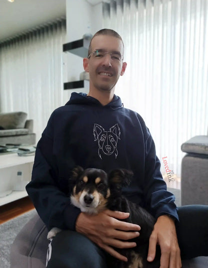 Man holding puppy wearing navy custom embroidered hoodie with minimalist dog portrait (Lovedink)