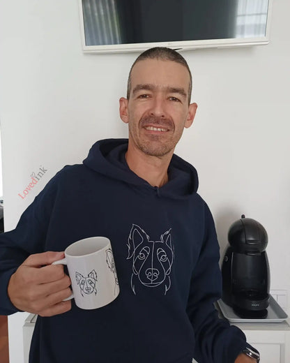 Man wearing navy custom embroidered hoodie with minimalist pet line art holding a mug (Lovedink)