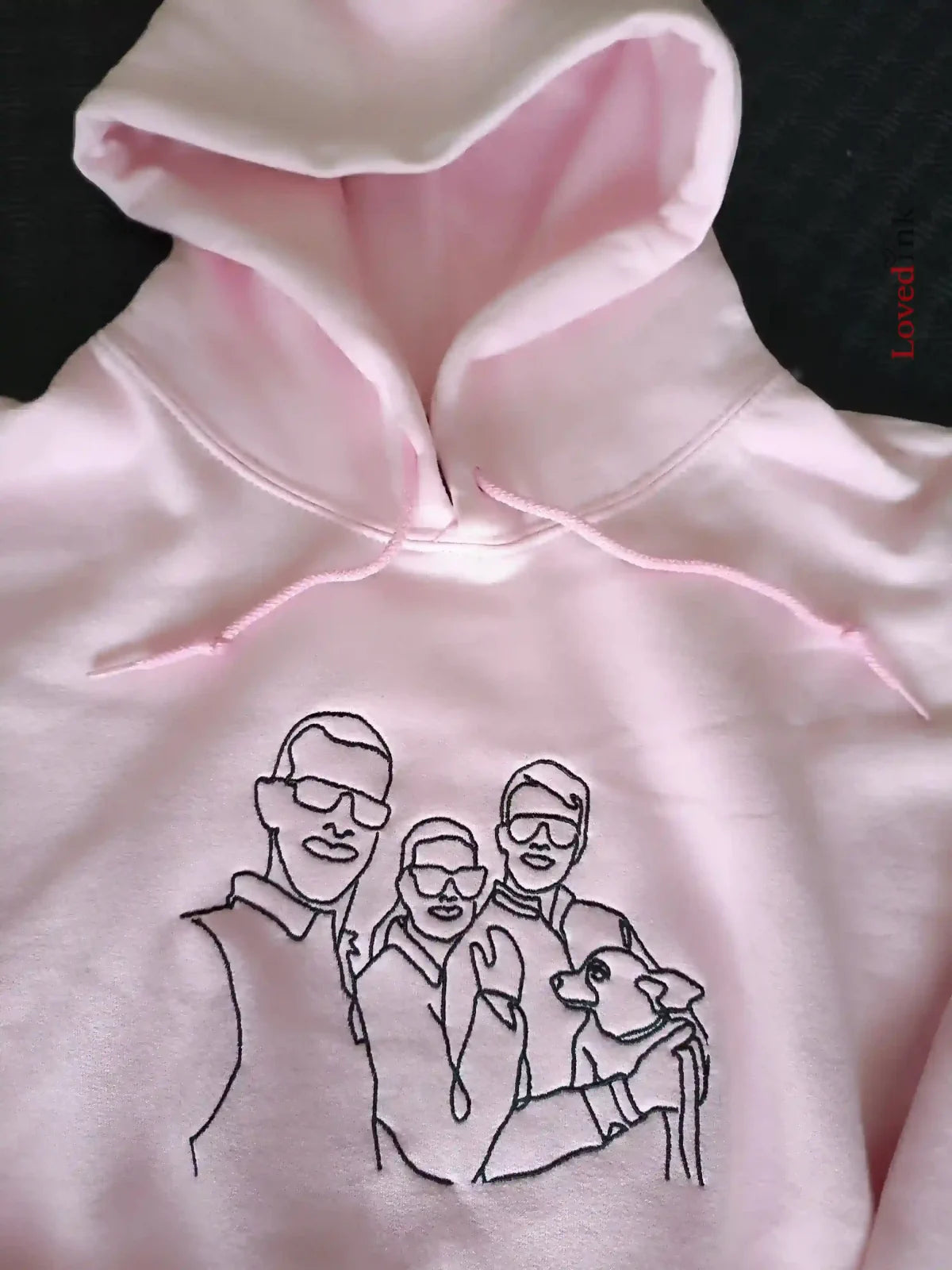 Close-up of pink custom embroidered hoodie with minimalist line art portrait (Lovedink)