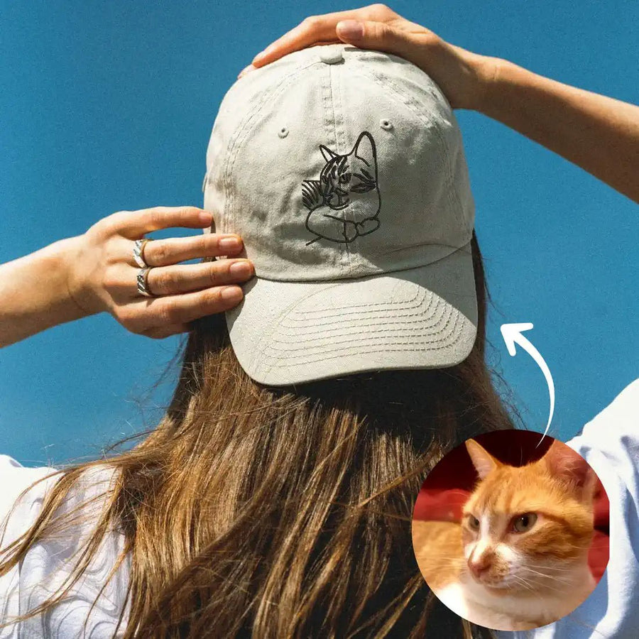 Woman wearing custom embroidered cap holding a cat — personalized pet gift (Lovedink)