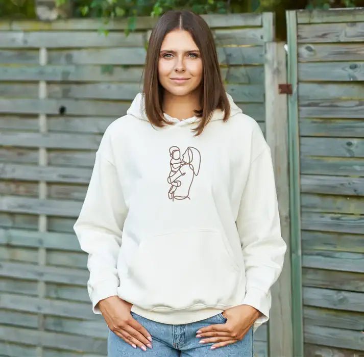 Woman wearing white custom embroidered hoodie with minimalist line art design (Lovedink)