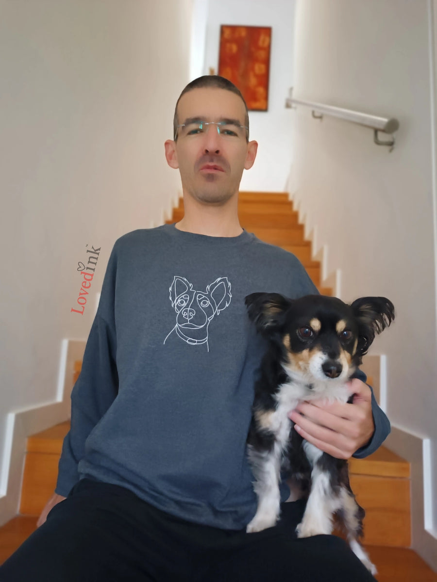 Man with dog wearing dark grey custom embroidered sweatshirt with minimalist pet portrait (Lovedink)