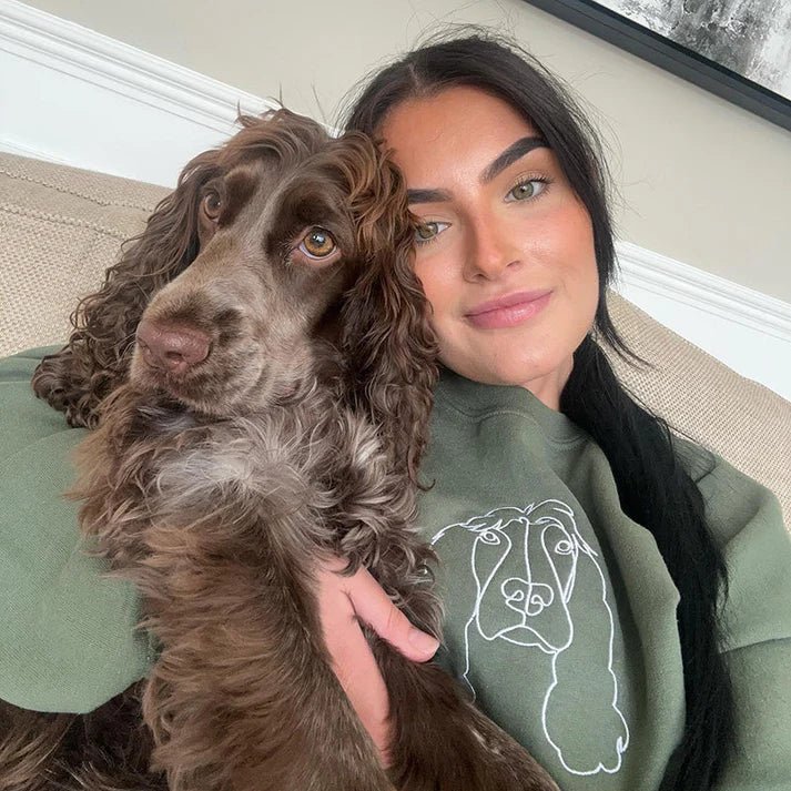 Woman with dog wearing green custom embroidered sweatshirt with minimalist pet portrait