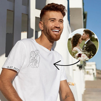 Man wearing a white t-shirt with a printed design and date, standing outdoors.