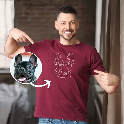 Man wearing a maroon t-shirt with a dog graphic, pointing to the design.